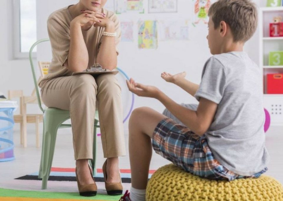 Eine Frau spricht mit einem Jungen in einem Klassenzimmer.