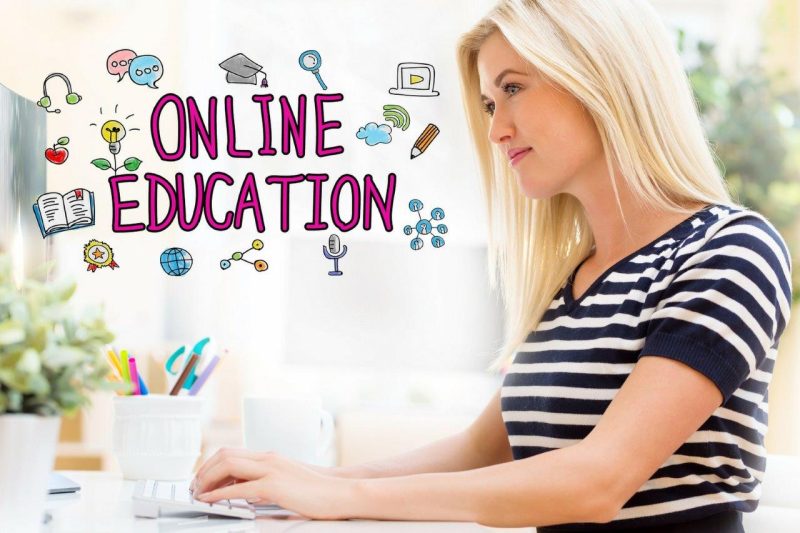 Eine Frau sitzt an einem Schreibtisch, auf dem das Wort „Online-Bildung“ steht.